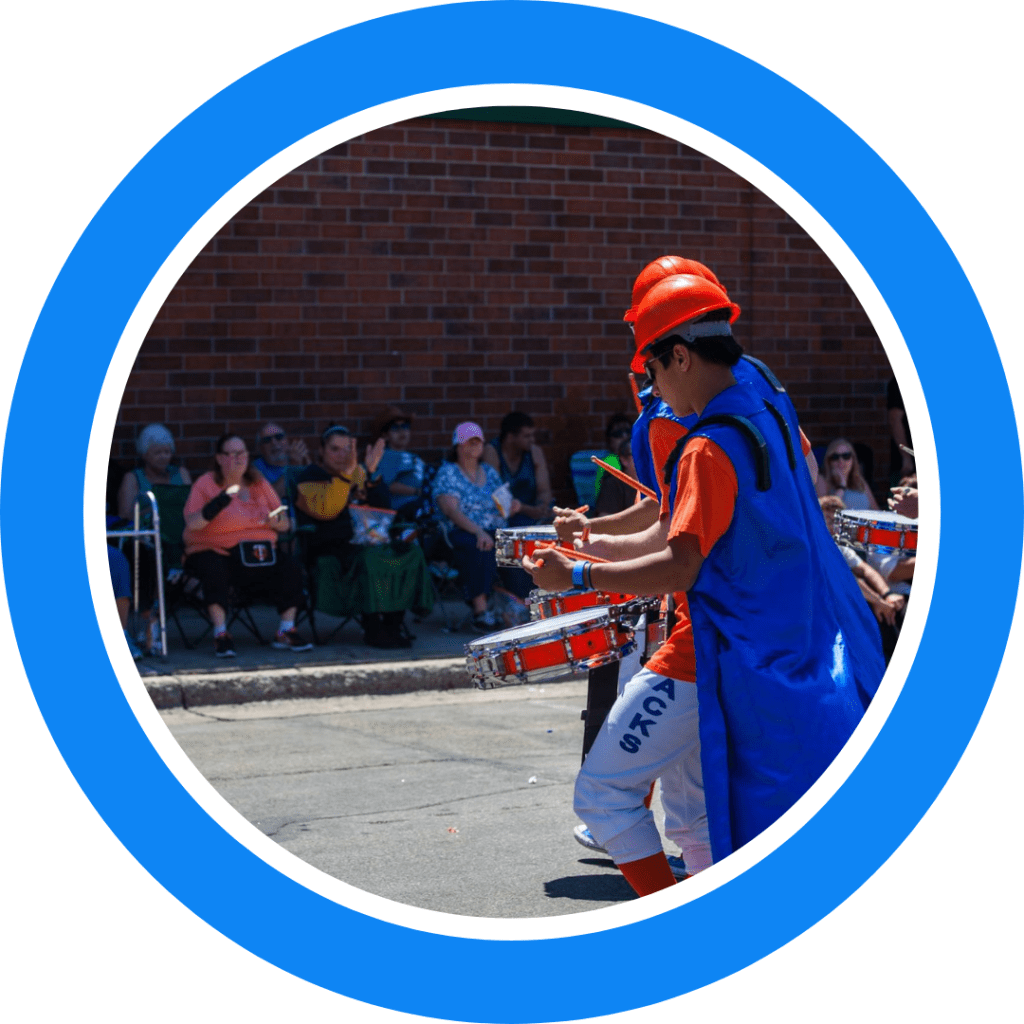 The Kracker Jacks Drumline playing at a parade for a group of people